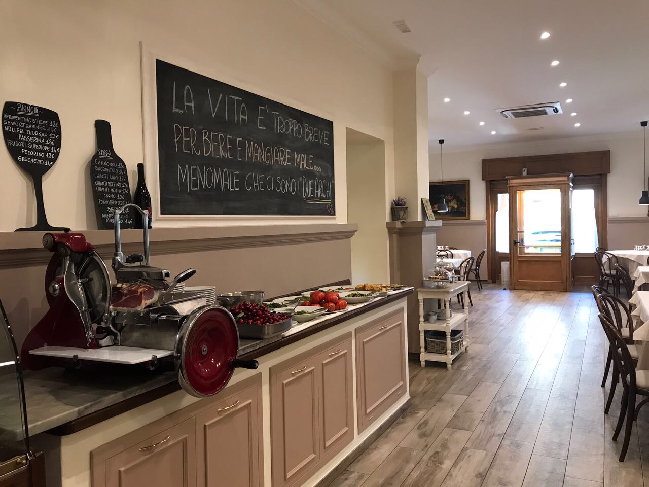 Bancone della Trattoria Due Archi con affettatrice e lavagna scritta a mano