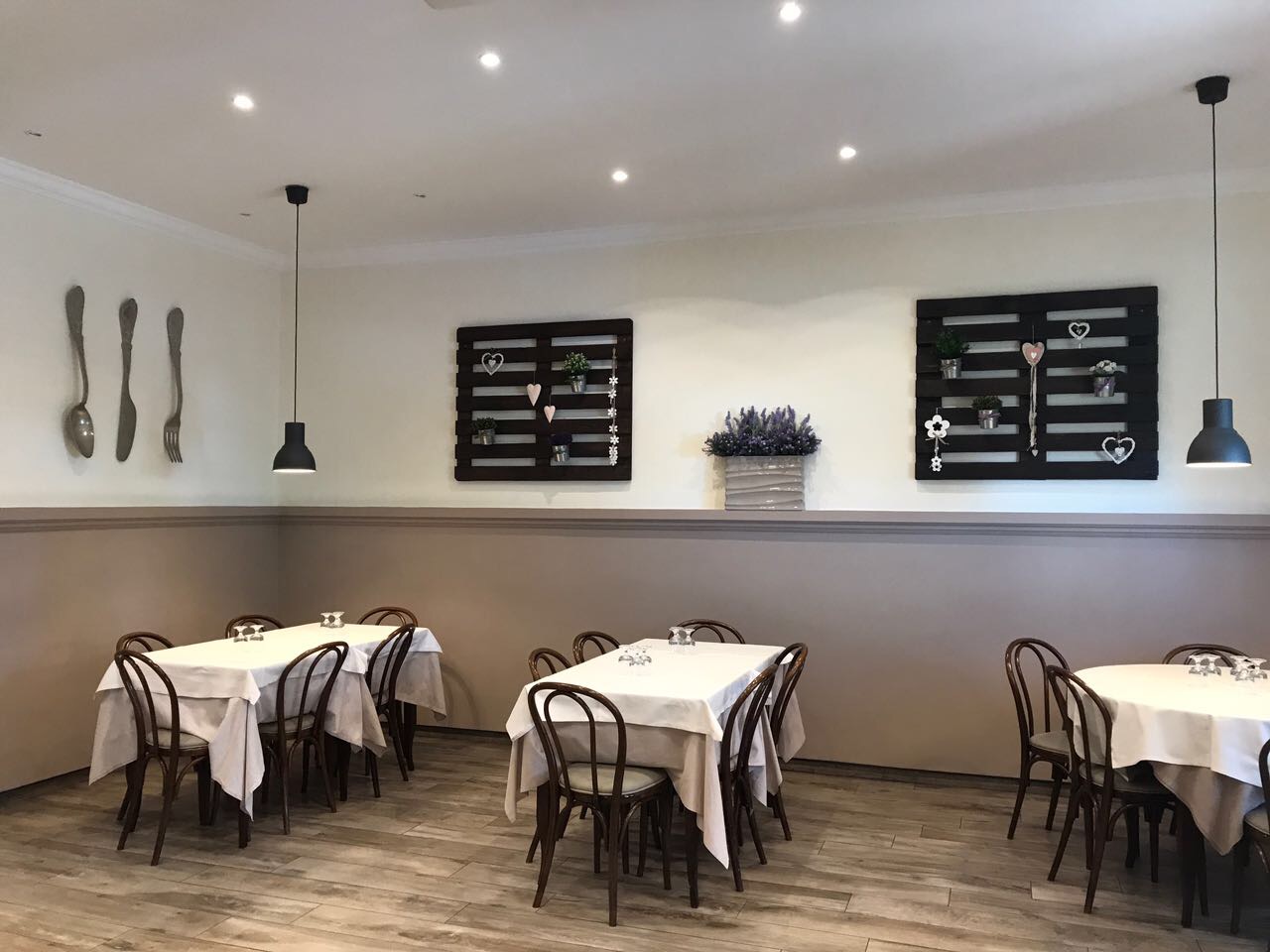 Sala interna della Trattoria Due Archi con tavoli apparecchiati e decori alle pareti